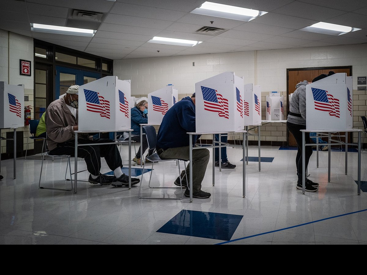A row of white voting booths with American flags at a Des Moines polling place on Election Day 2020.